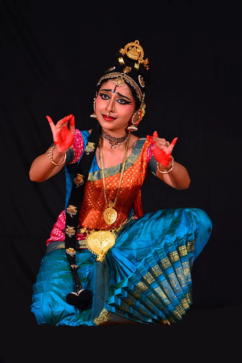 Kuchipudi dancer posing with a mobile in her hand - SuperStock